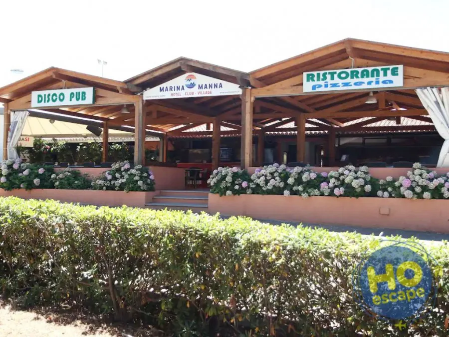 Ristorante pizzeria e disco pub con strutture in legno e siepi fiorite all'esterno
