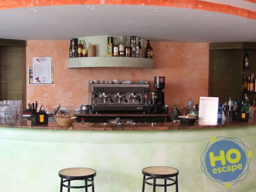 Bancone bar con macchina del caffè professionale e bottiglie di liquori
