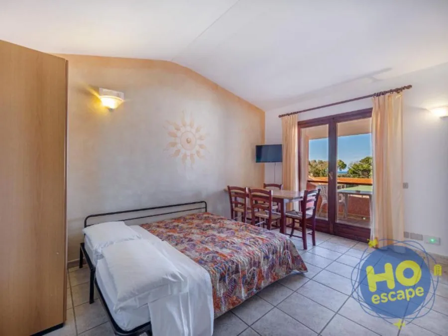 Camera con letto matrimoniale, zona pranzo e balcone con vista mare