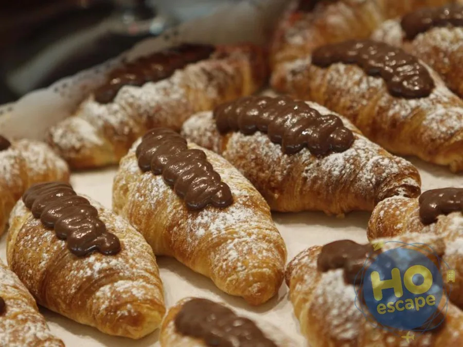 Cornetti freschi spolverati di zucchero a velo e farciti con crema al cioccolato