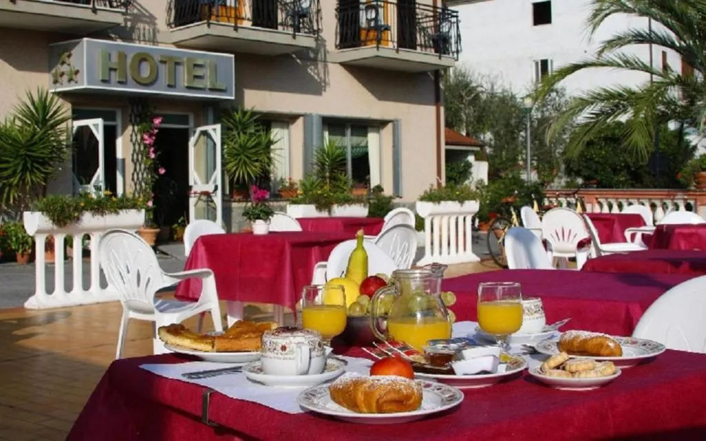 Colazione all'aperto su tavoli con tovaglia rossa davanti all'ingresso dell'hotel
