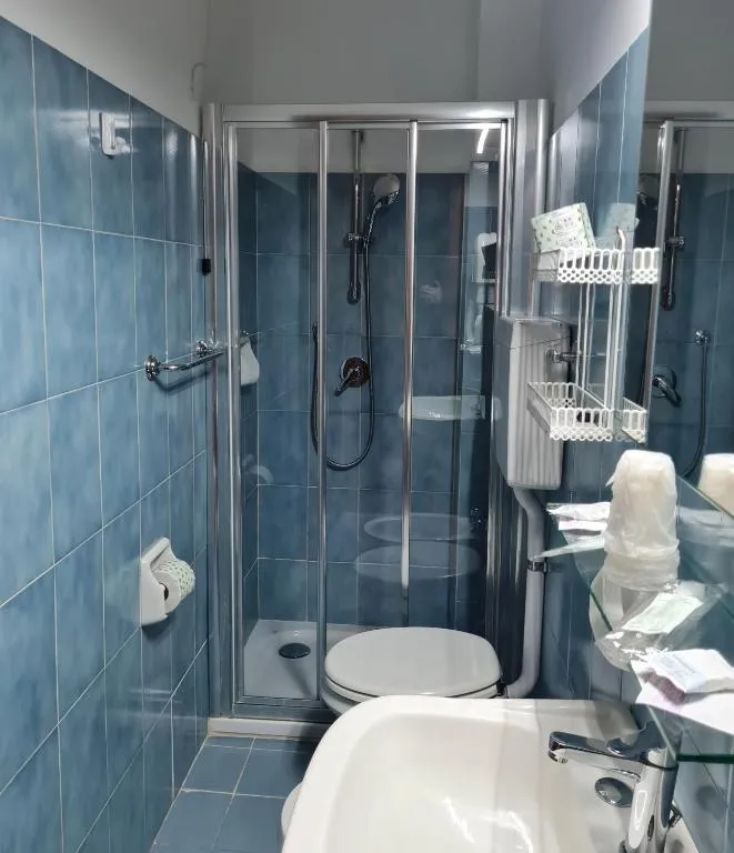 Bagno con doccia, sanitario e piastrelle azzurre