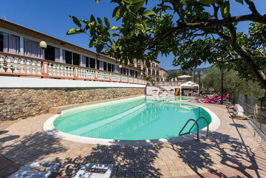 Piscina esterna circondata da terrazza in cotto e muro in pietra