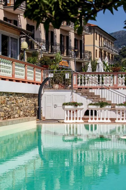 Piscina con acqua turchese e facciata dell'hotel sullo sfondo