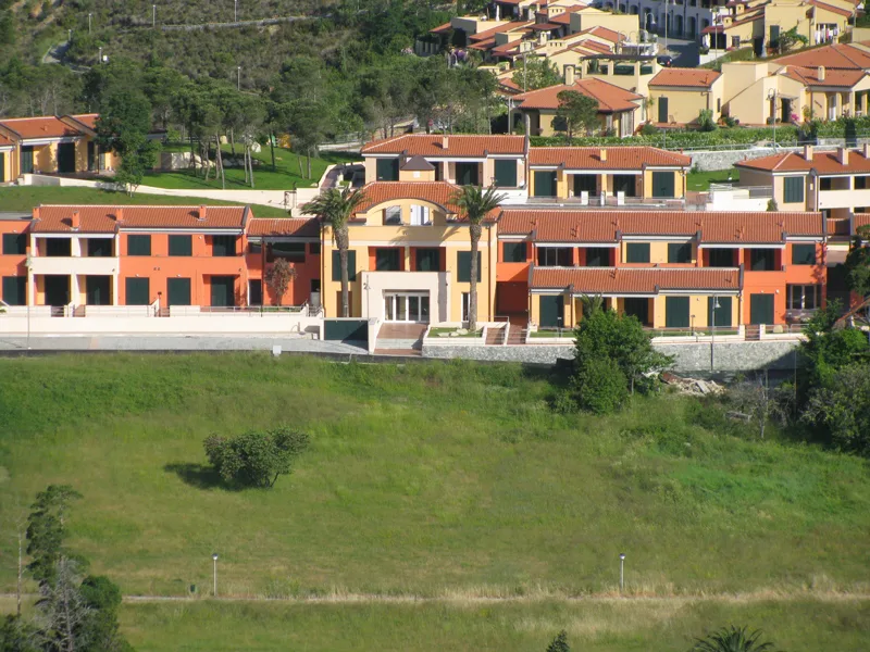 Edificio principale del residence con facciata arancione immerso nel verde collinare