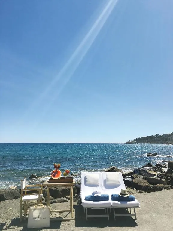 Lettini con asciugamani e tavolino con frutta affacciati sul mare in una giornata di sole