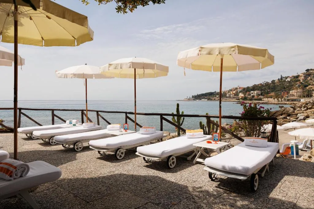 Lettini con ombrelloni e asciugamani affacciati sul mare lungo la costa