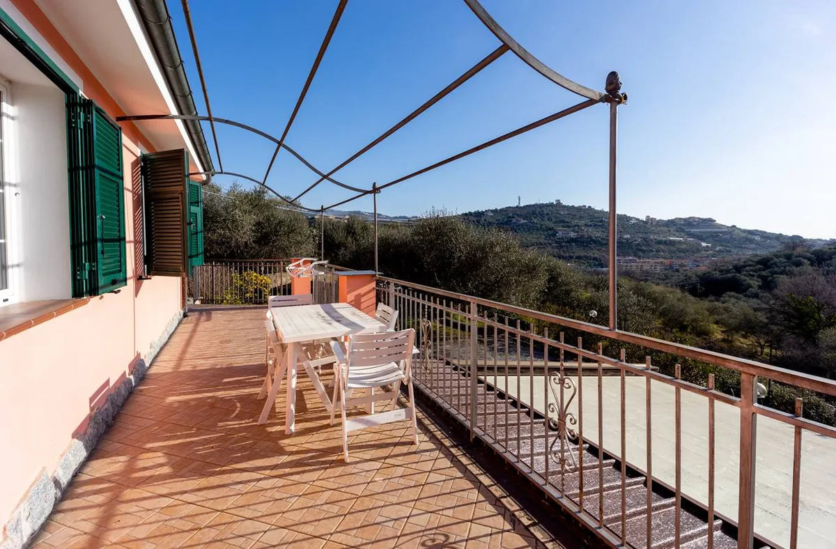 Ampia terrazza con tavolo bianco e vista panoramica sulle colline circostanti