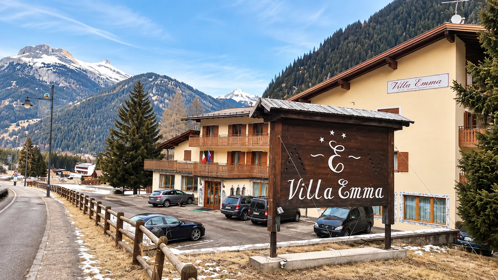Esterno dell'hotel Villa Emma con parcheggio e insegna in legno in primavera