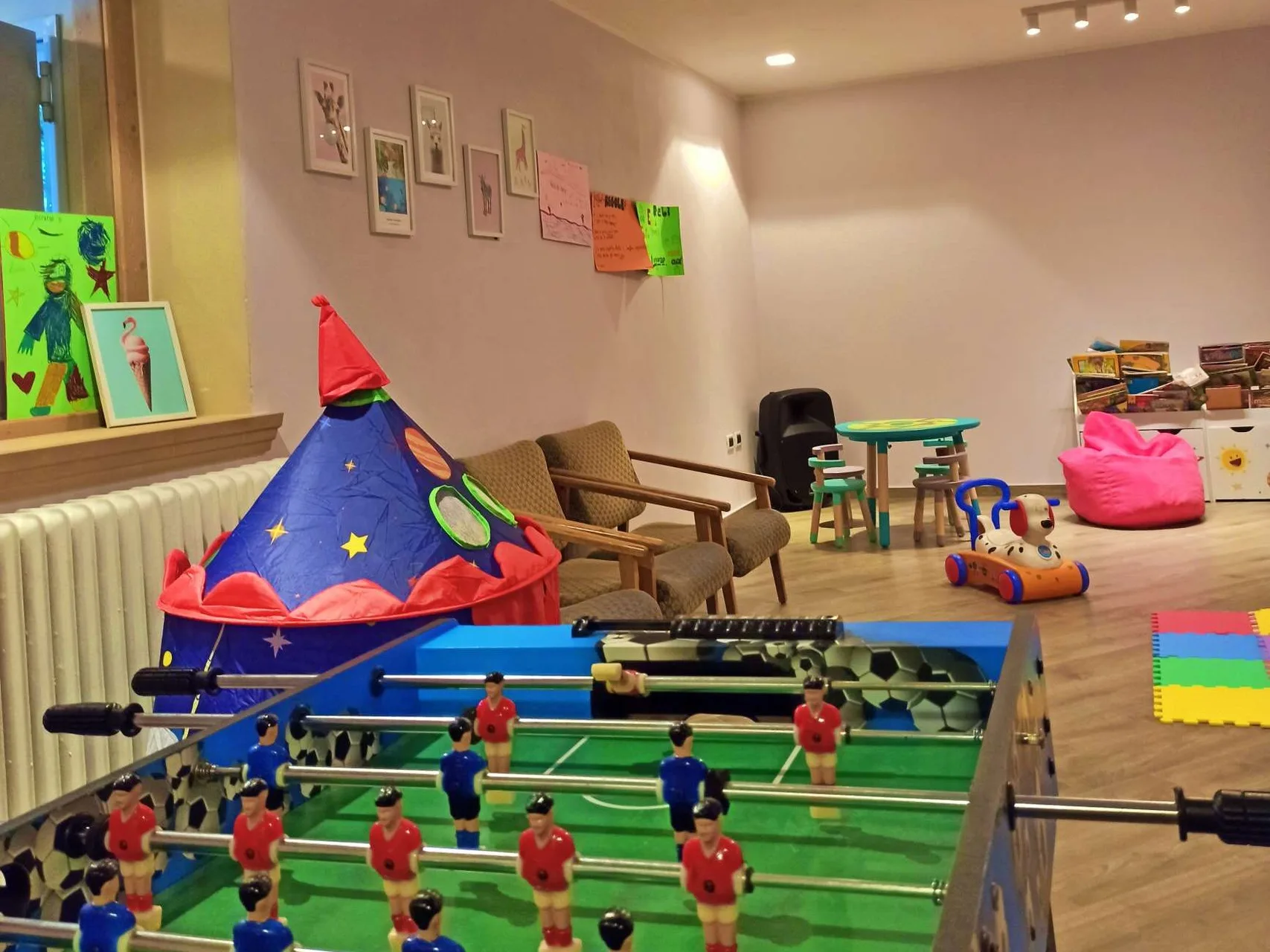 Sala giochi per bambini con calcio balilla, tenda a razzo, giochi e area lettura