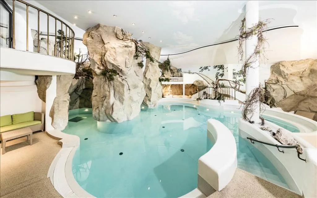 Piscina coperta con formazioni rocciose decorative e vegetazione