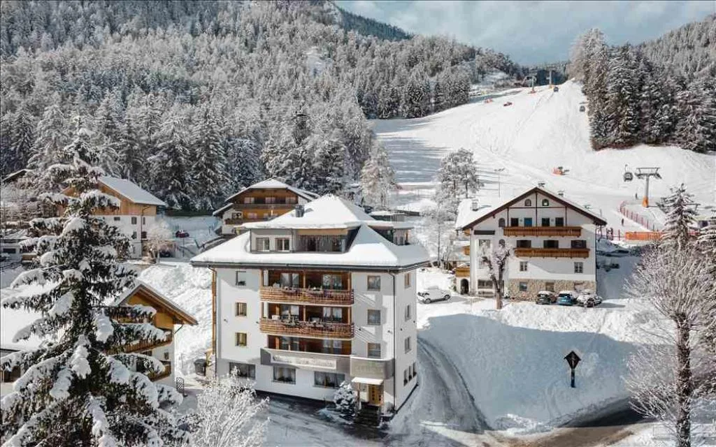 Vista aerea dell'hotel innevato ai piedi delle piste da sci in inverno