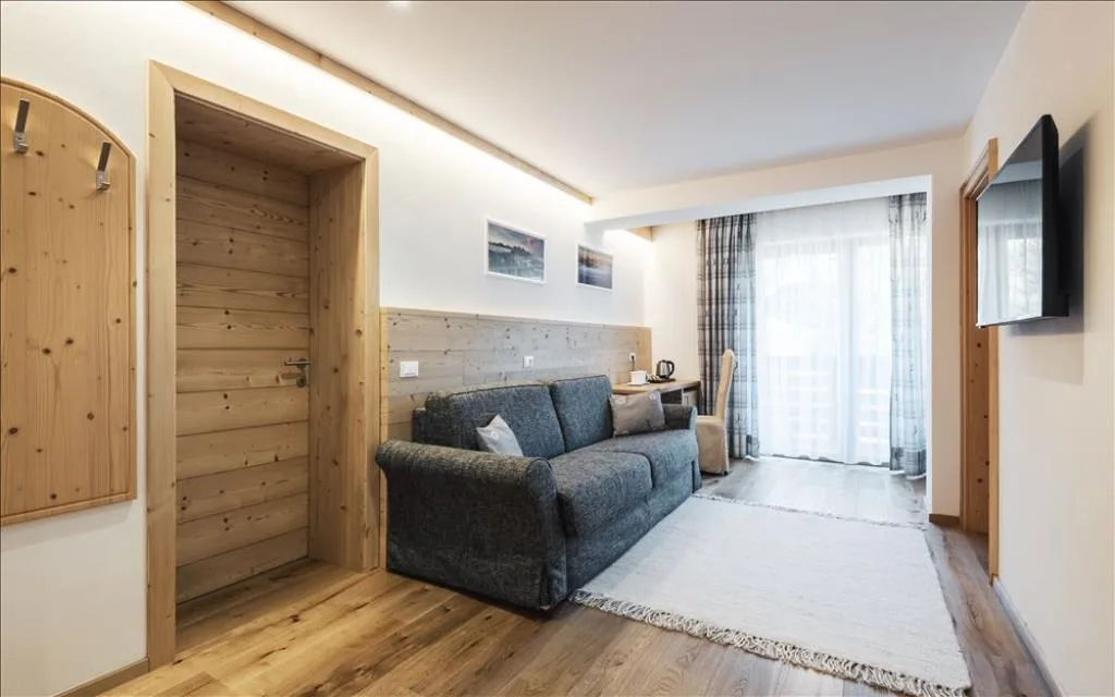 Camera con divano grigio, TV e arredi in legno naturale