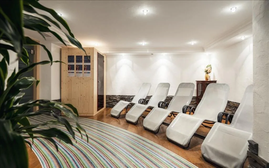 Zona benessere con lettini relax e cabina sauna in legno