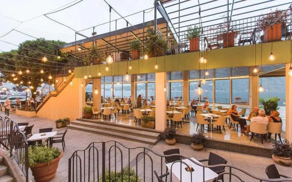 Ristorante con veranda in vetro affacciata sul lago e illuminazione serale