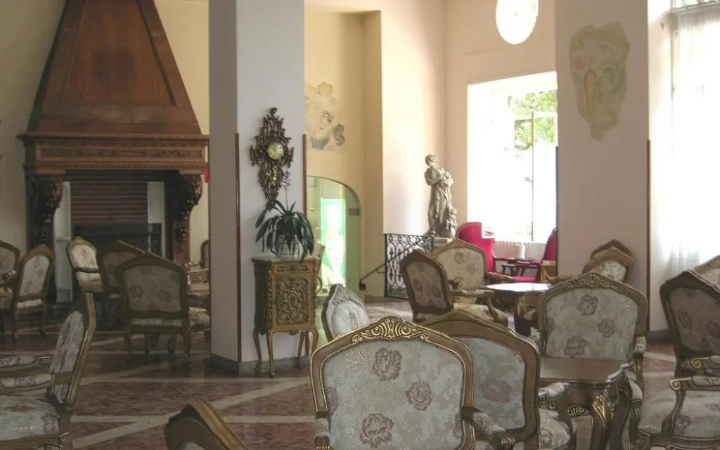 Sala comune classica con camino, poltrone imbottite e pavimento in marmo