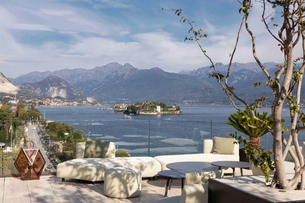 Terrazza lounge con divani bianchi e vista panoramica sull'Isola Bella e il lago