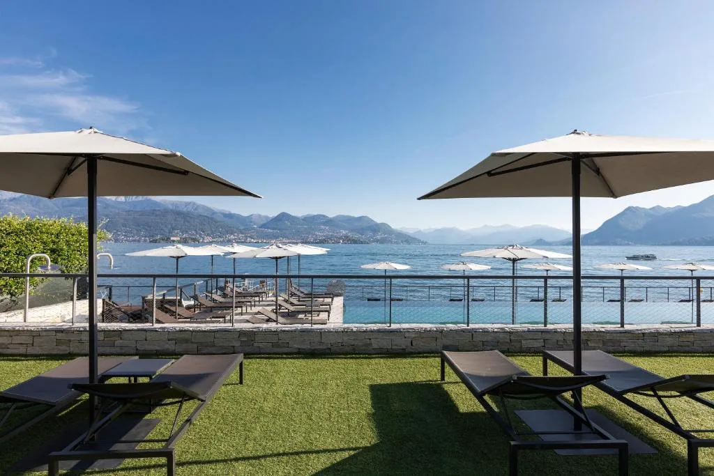 Prato con lettini e ombrelloni affacciato sulla piscina e sul Lago Maggiore