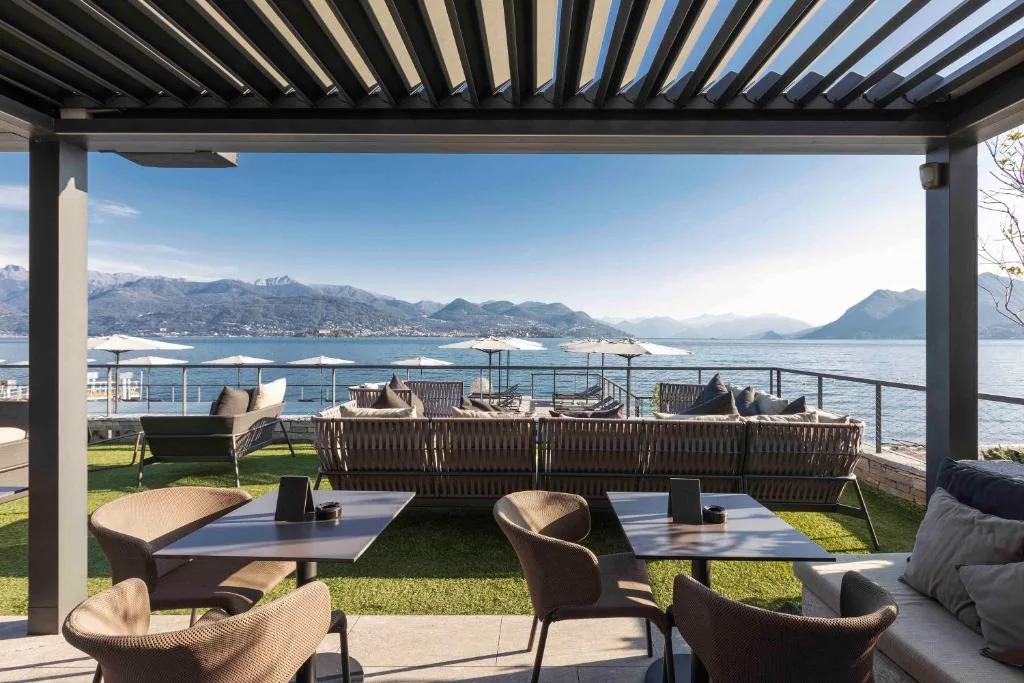 Terrazza ristorante con pergola, divani e tavoli con vista sul lago e le montagne
