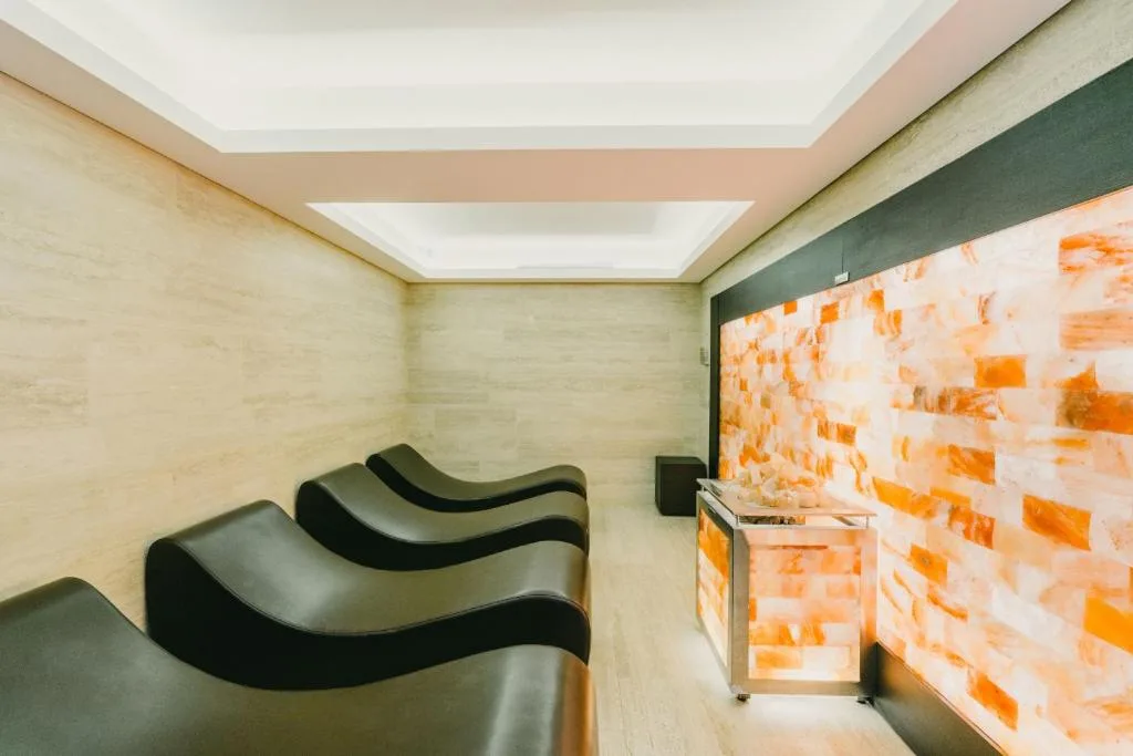 Sala relax della spa con lettini ergonomici e parete in sale rosa dell'Himalaya