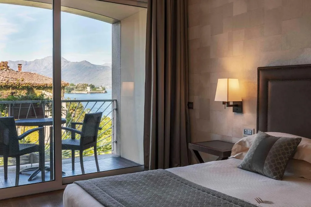 Camera con letto e balcone con tavolino e vista sull'Isola Bella e il lago