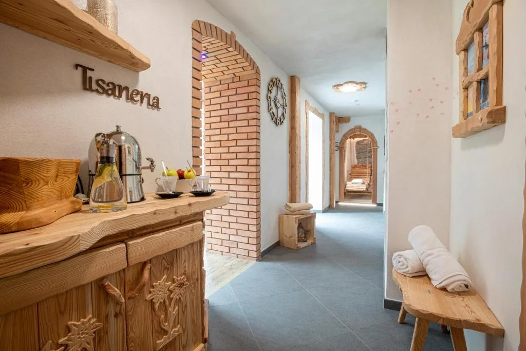 Corridoio della spa con tisaneria, arco in mattoni e panca in legno con asciugamani