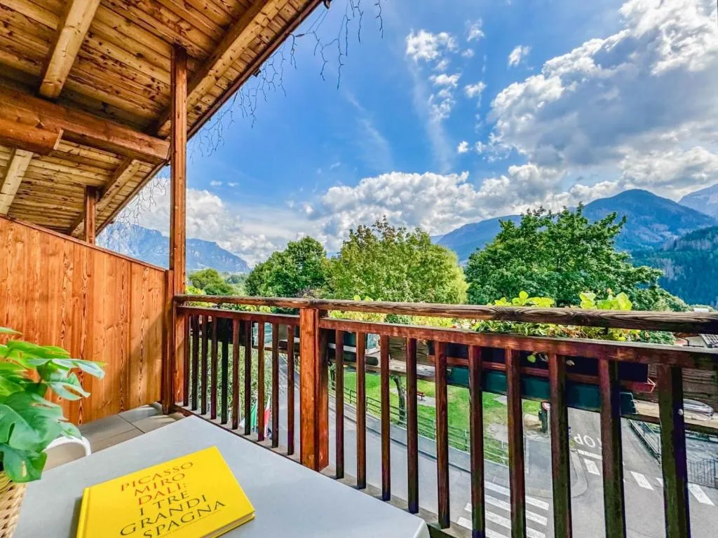 Balcone in legno con tavolino e vista panoramica sulle montagne