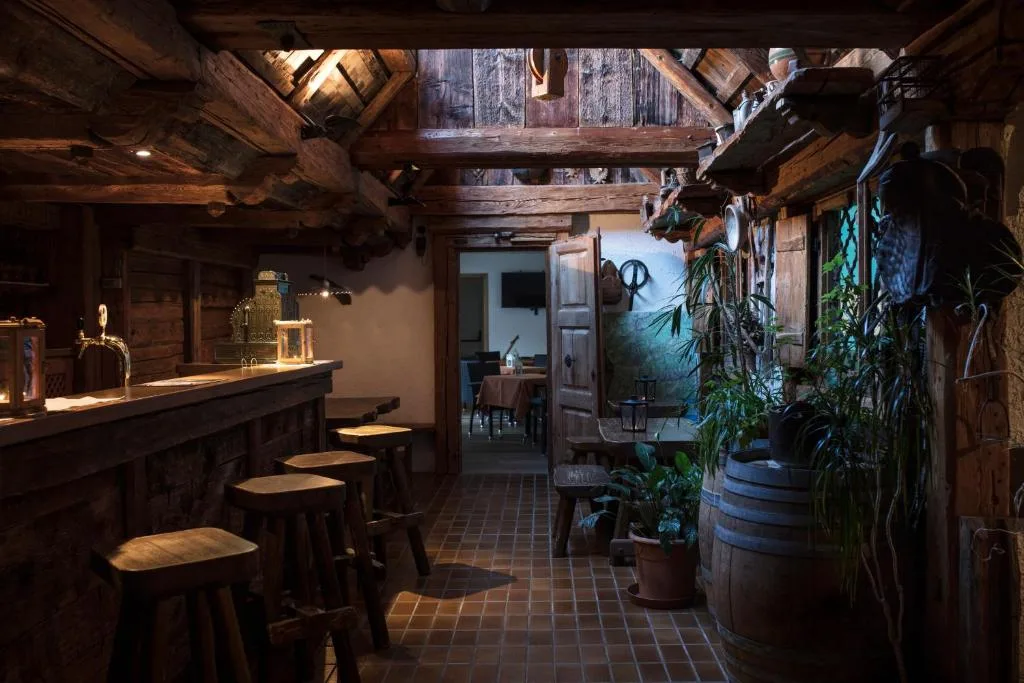 Bar rustico con bancone e sgabelli in legno e arredi tradizionali