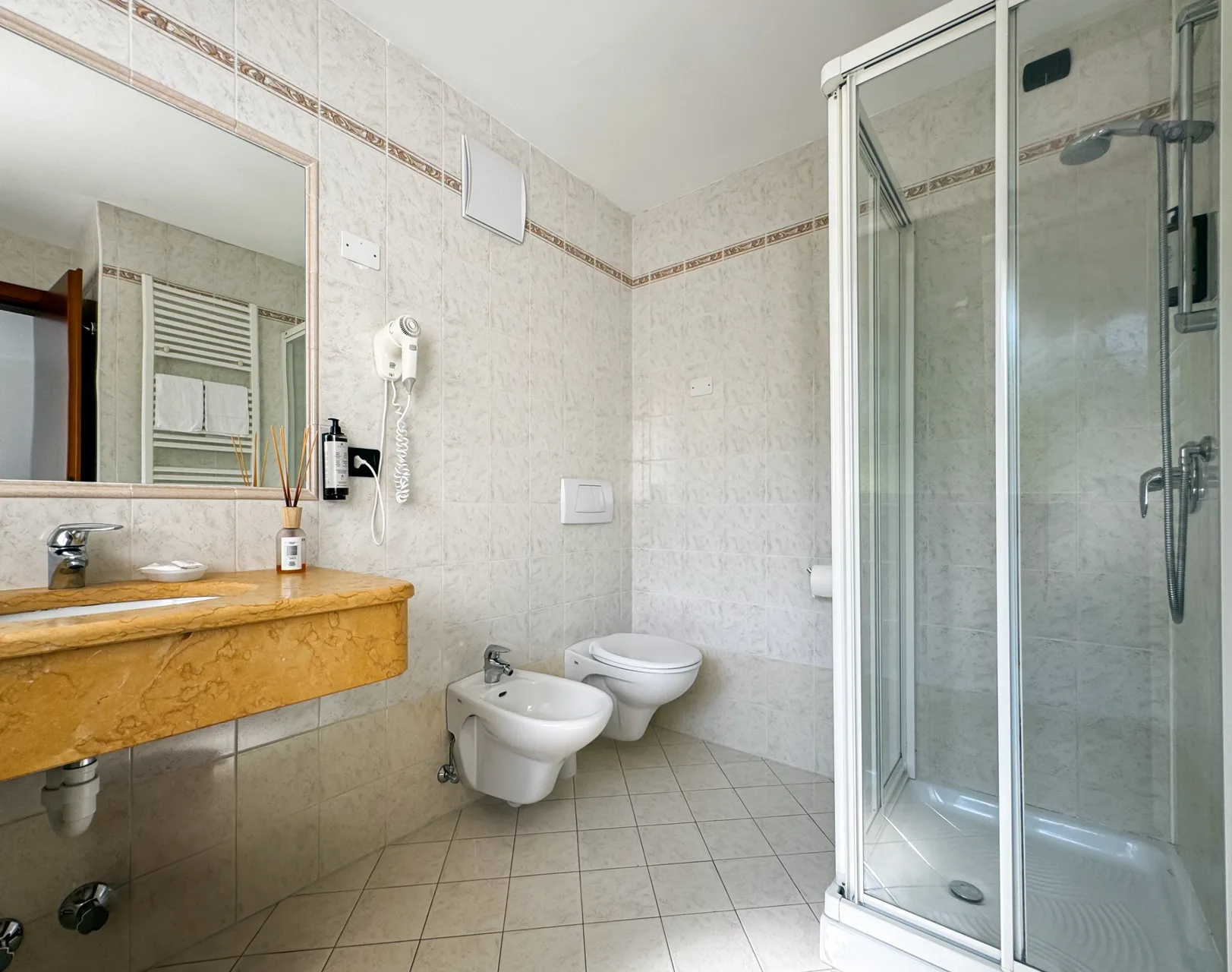 Bagno con doccia, lavabo in marmo, bidet e WC in stile classico