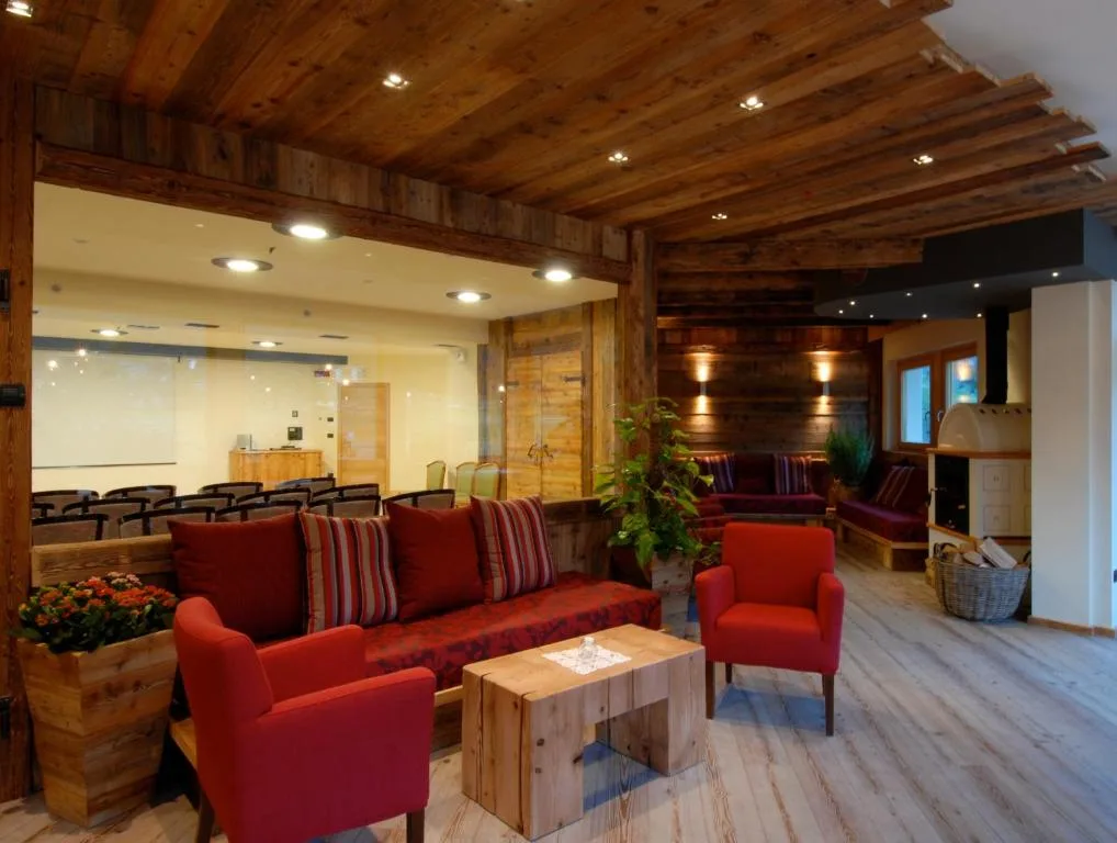 Salotto con poltrone rosse, tavolino in legno e soffitto con travi a vista