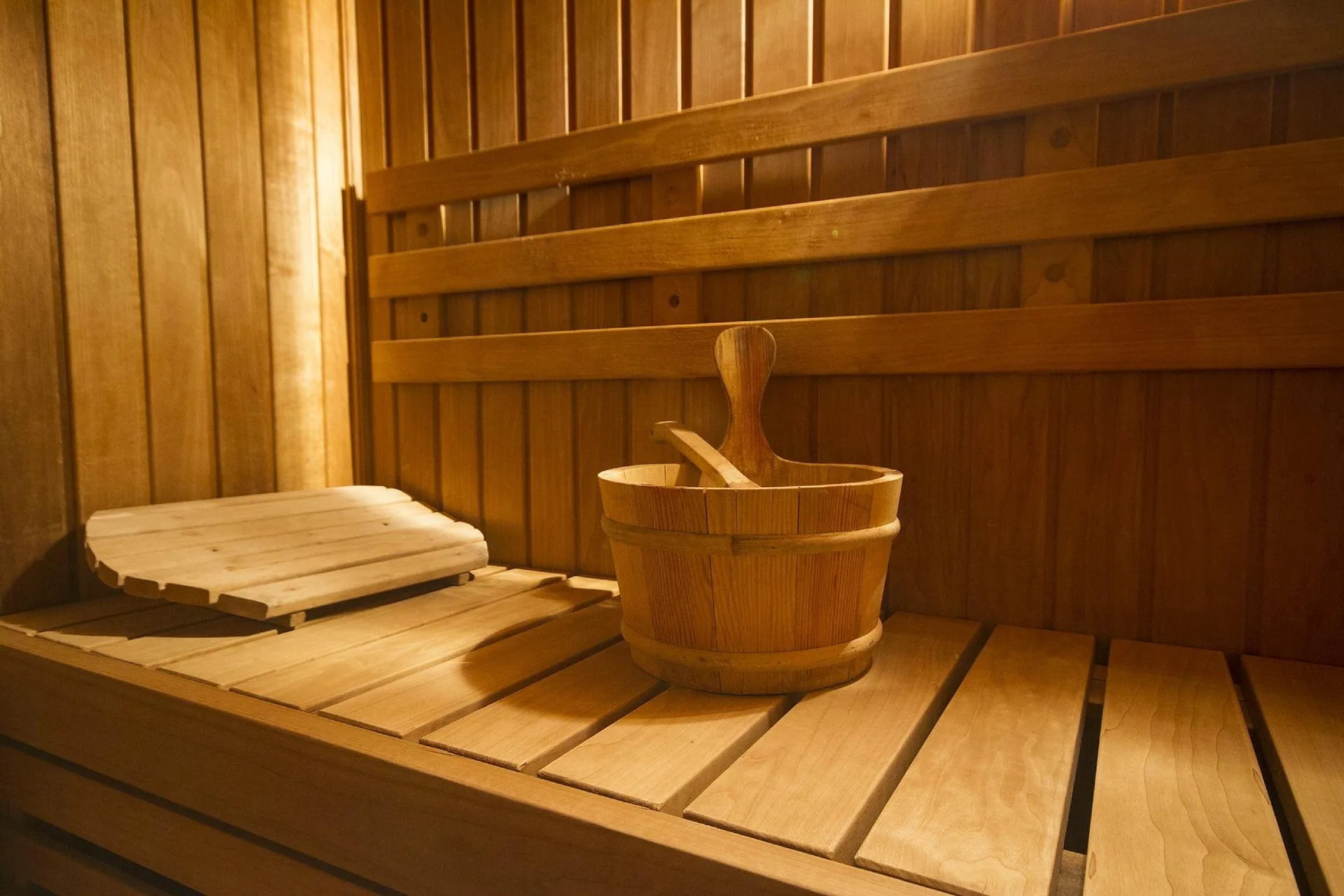 Dettaglio della sauna con secchiello in legno e panche