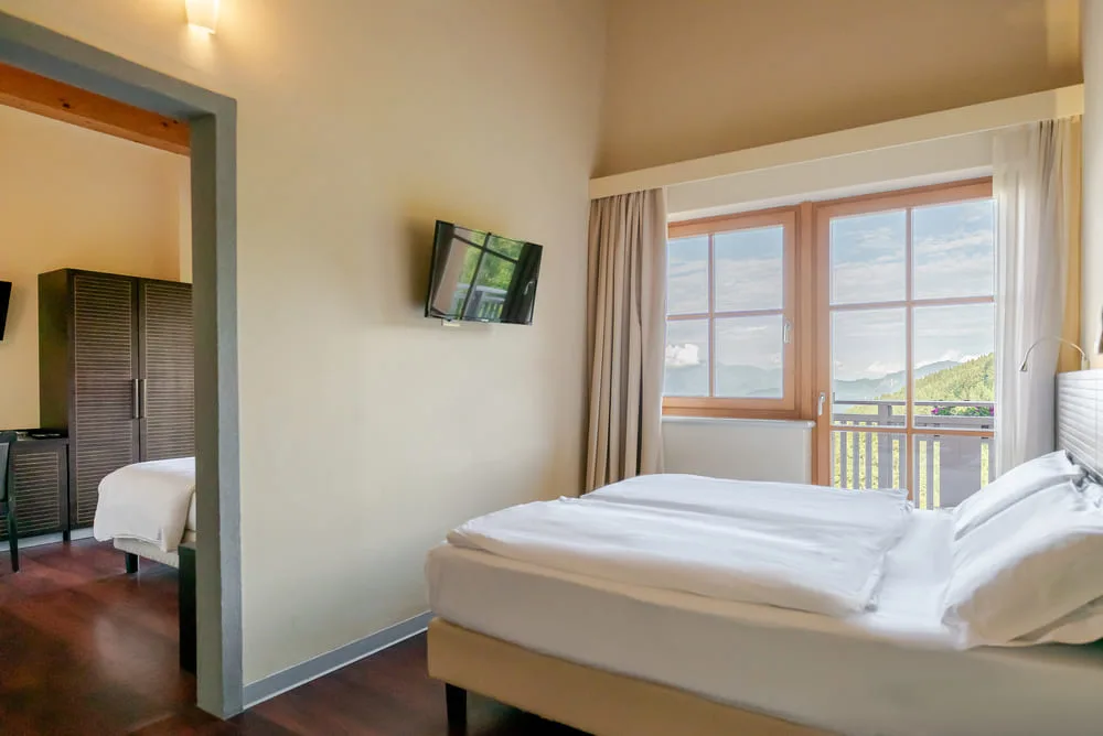 Camera con letto matrimoniale e finestra panoramica sulle montagne