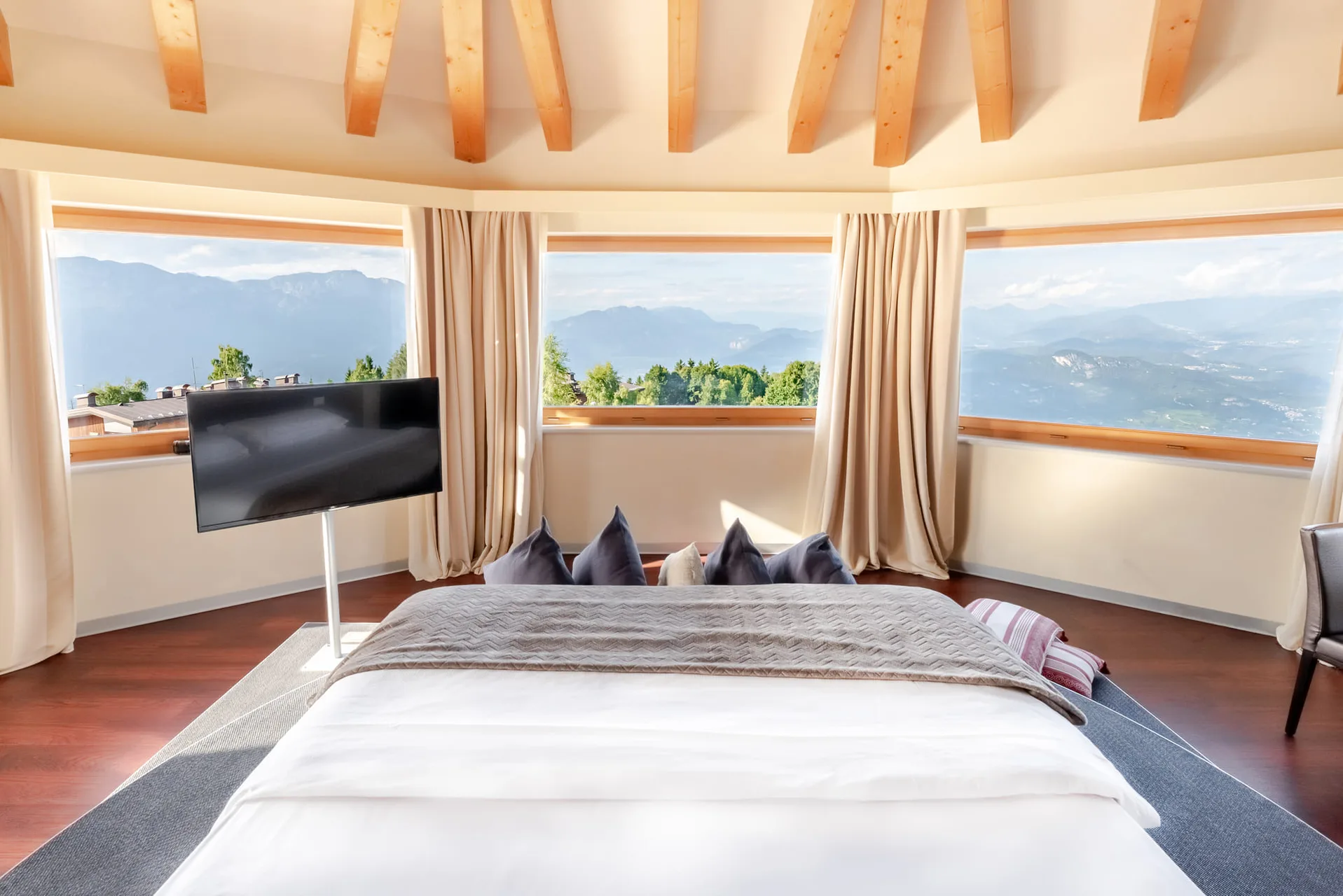 Suite con letto e ampie finestre panoramiche sulle montagne e la valle