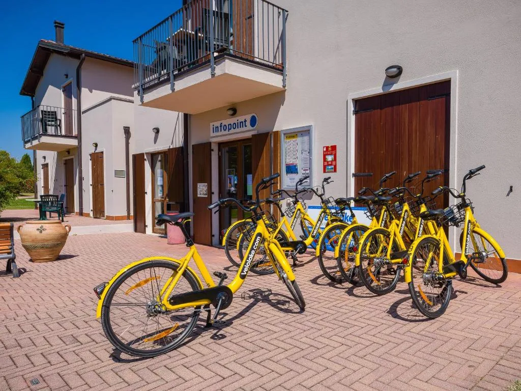 Biciclette gialle a noleggio parcheggiate davanti all'infopoint della struttura