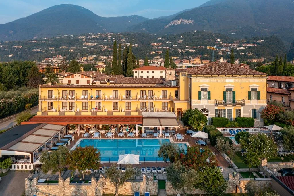 Veduta aerea dell'hotel con piscina, giardino e montagne sullo sfondo