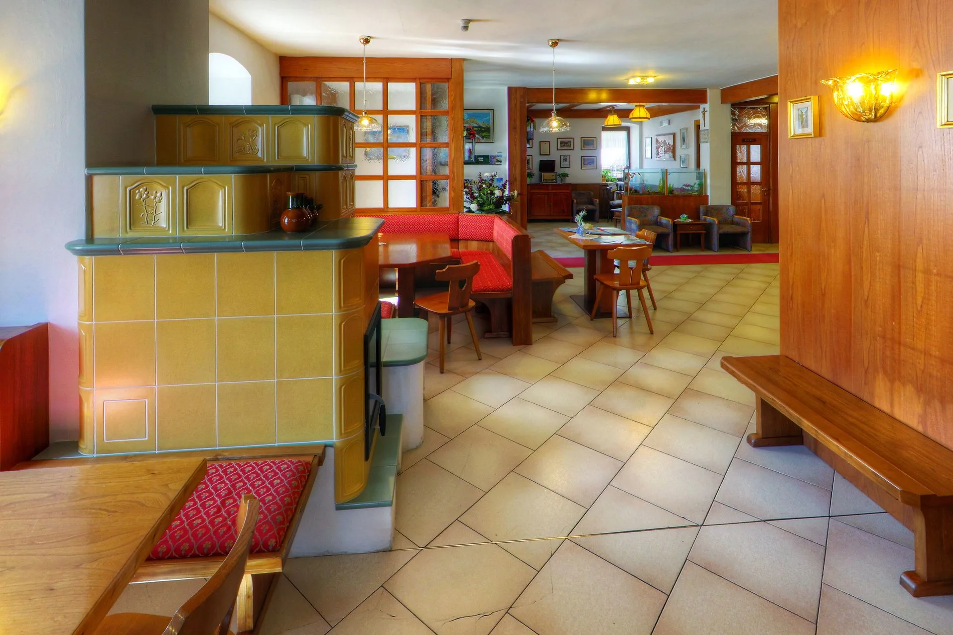 Area lounge con bancone bar in legno e stufa a maiolica
