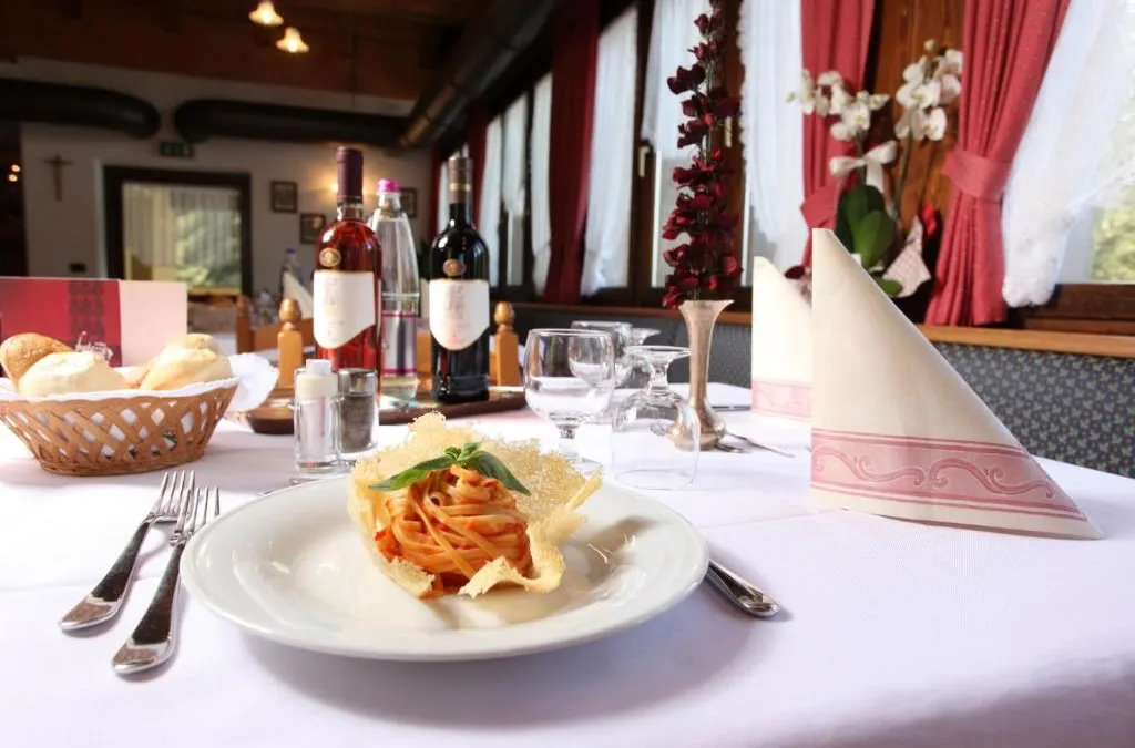 Tagliatelle al pomodoro con cialda di parmigiano su tavolo elegante