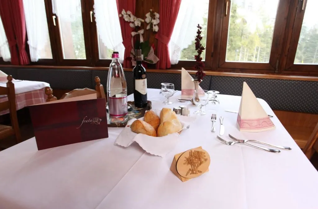 Tavolo apparecchiato con pane, vino e vista sui boschi