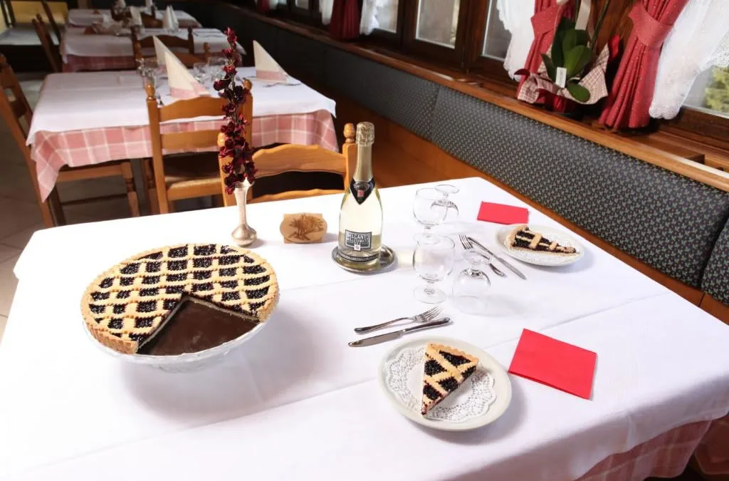Crostata ai frutti di bosco e spumante su tavolo del ristorante