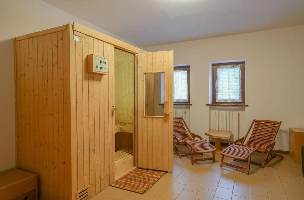Area sauna con cabina in legno e lettini relax