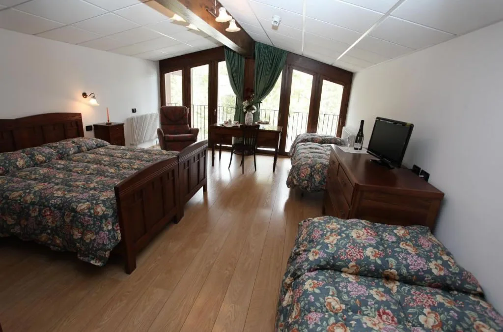 Camera con letto matrimoniale, parquet e affaccio con terrazzino