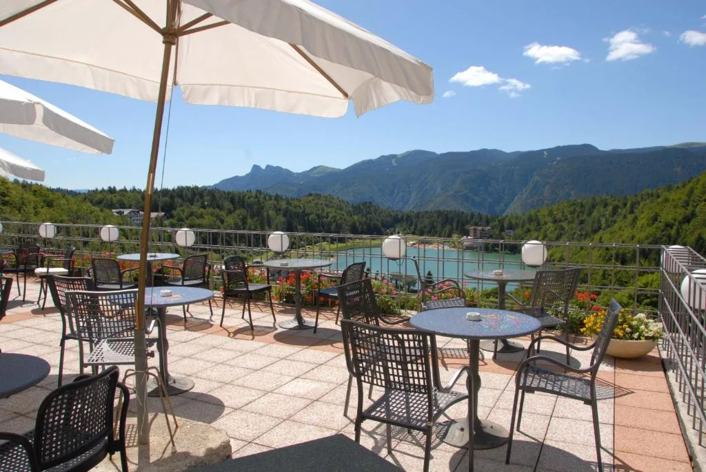 Terrazza panoramica con ombrelloni e vista sul lago alpino