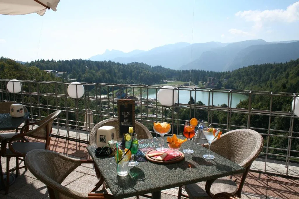 Tavolo con aperitivi e cocktail sulla terrazza panoramica affacciata sul lago