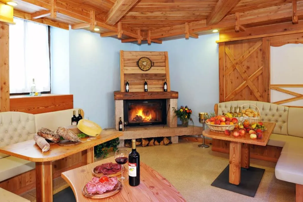 Accogliente sala con camino acceso e taglieri di salumi e formaggi