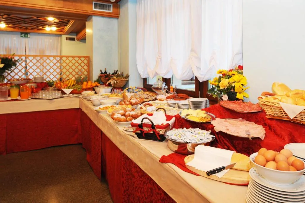 Buffet della colazione con salumi, dolci, pane e uova