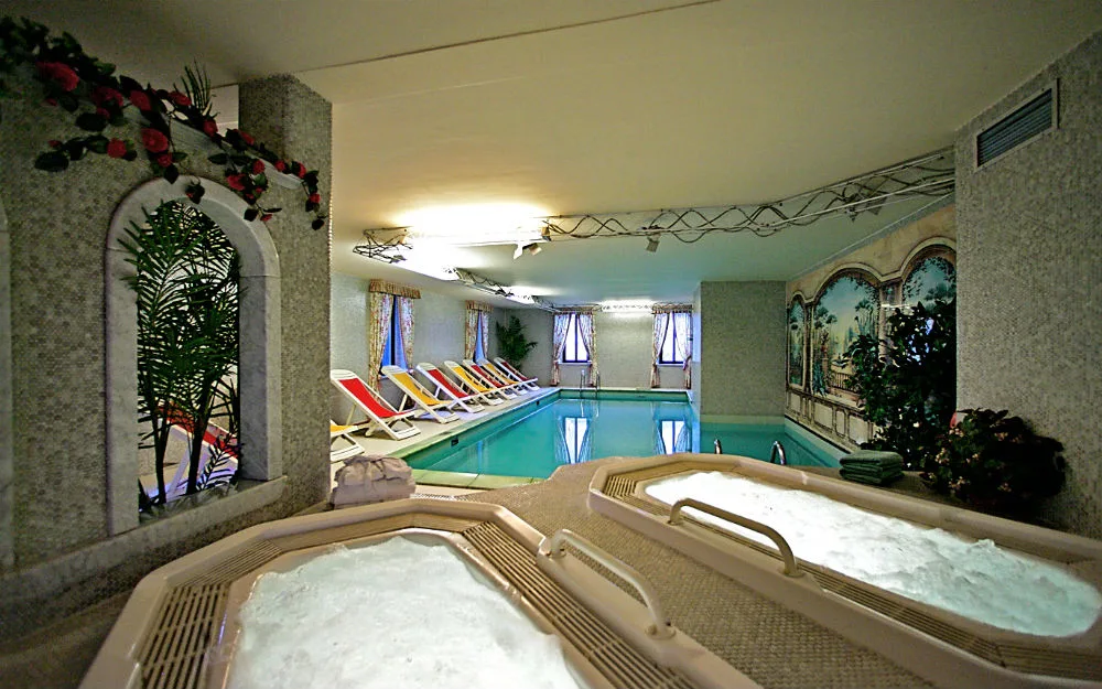 Piscina interna coperta con idromassaggi e decorazioni floreali