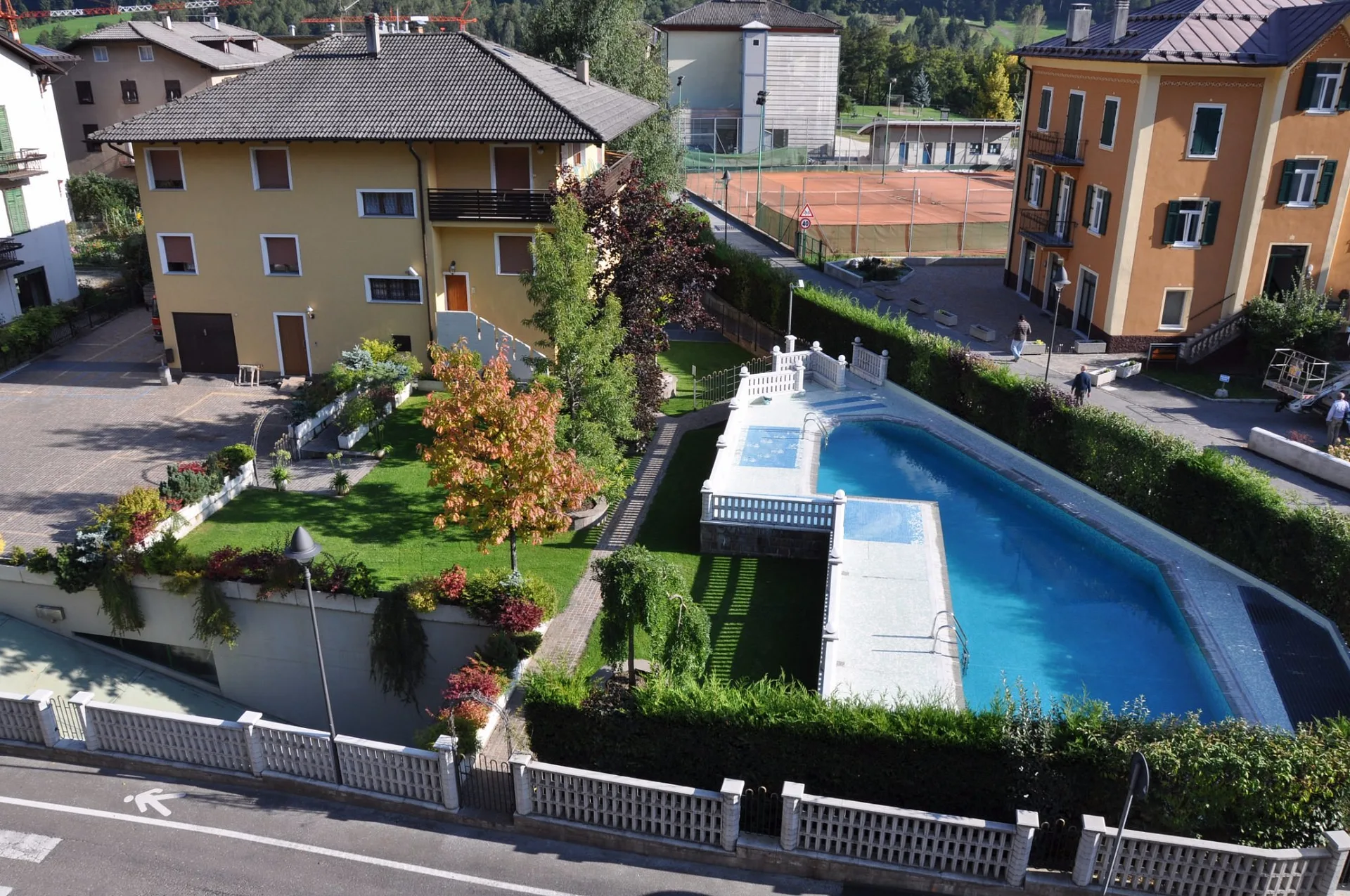 Vista aerea della piscina esterna dell'hotel con giardino e lettini