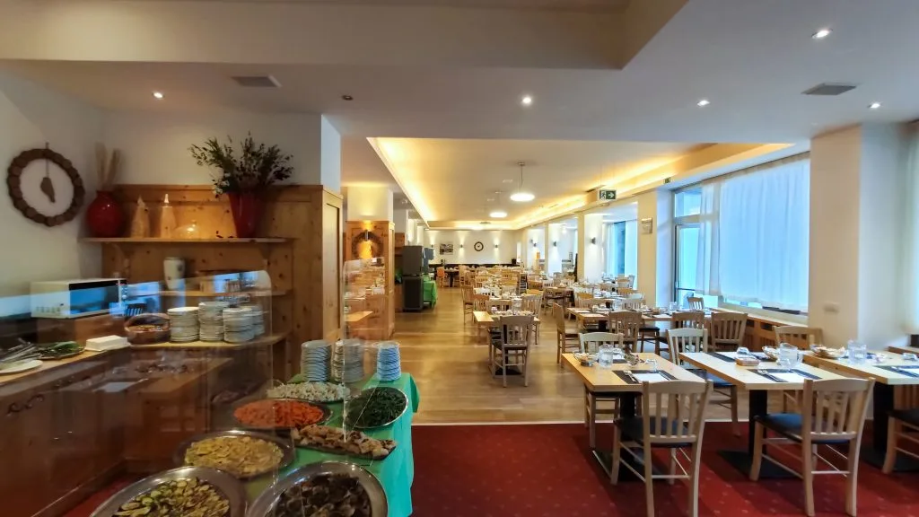 Sala ristorante con buffet, tavoli in legno e ampie finestre