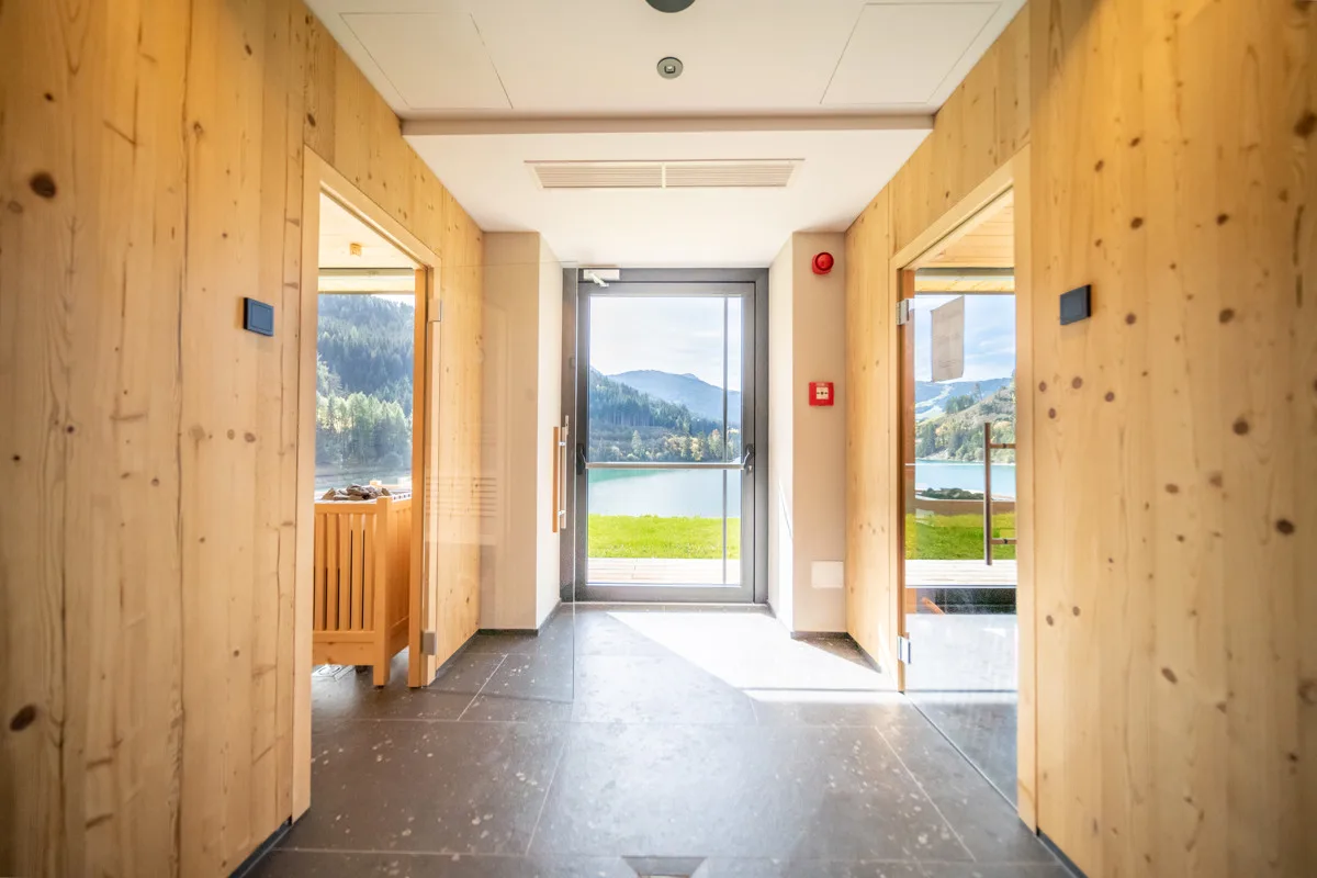 Corridoio della zona saune in legno con vista sul lago e sulle montagne