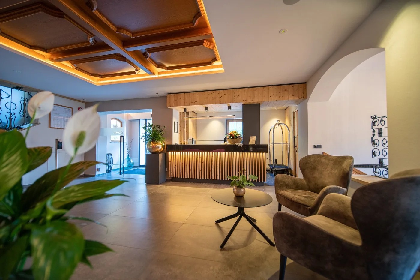 Reception dell'hotel con bancone in legno e poltrone in velluto